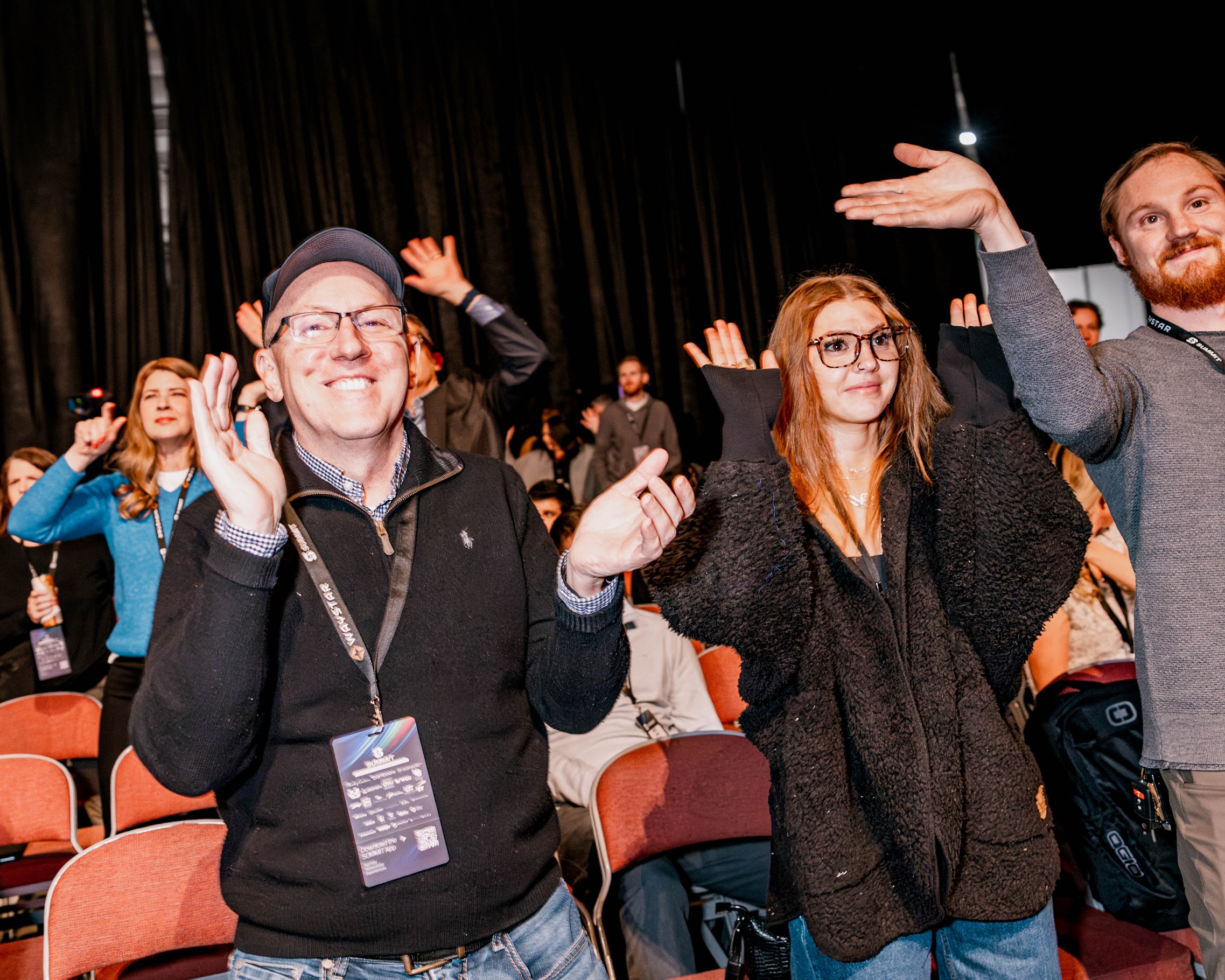 Conference attendees standing and joining an audience activity